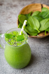 Spinach smoothie, on the grey  background.