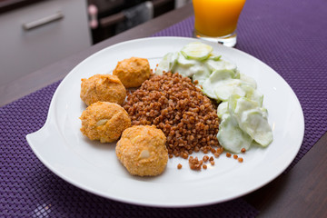 Chicken meatballs with diet buckwheat and sliced cucumber salad in yoghurt