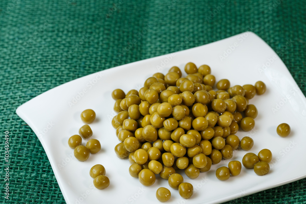 Wall mural green peas on a white plate