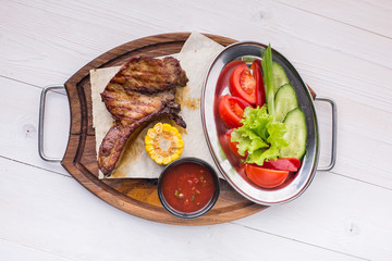 Tasty grilled ribs with vegetables. top view