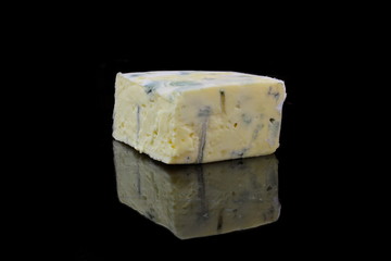 ein stück blauschimmelkäse auf schwarzen hintergrund
