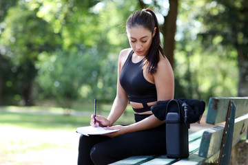 hübsche Frau schreibt Ihren Fitness Plan