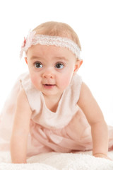 Baby girl trying to stand against white background
