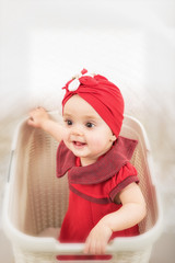 Upside portrait of baby girl into laundry basket having fun