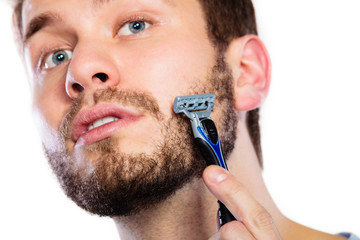 Young man with beard holding razor blade