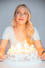 bautiful caucasian girl blowing candles on her cake