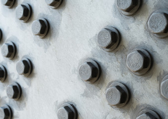 Gray metal surface with hexagonal bolt heads