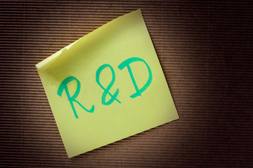 R&D (Research and Development) acronym on yellow sticky note