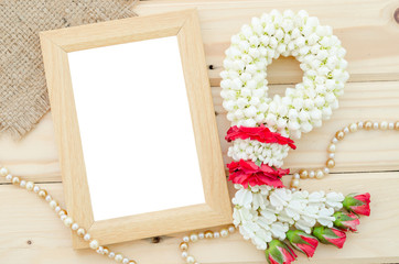 Blank wooden photo frame with flower.