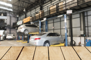 Empty top wooden table and blurred car technician repairing the