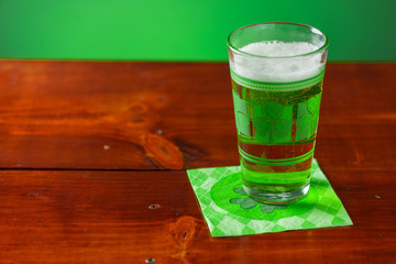 St. Patricks Day cold glass of green beer on a wood background