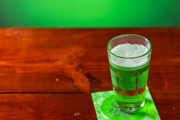 St. Patricks Day cold glass of green beer on a wood background