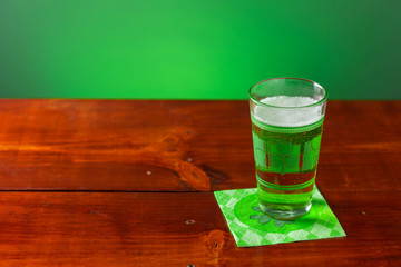 St. Patricks Day cold glass of green beer on a wood background