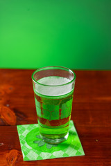 St. Patricks Day cold glass of green beer on a wood background