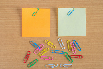 Note with a paper clip on wooden teble