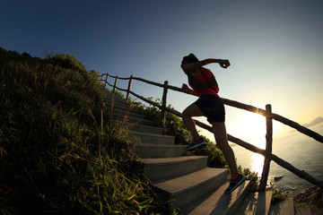 young fitness woman trail runner running up on mountain stairs