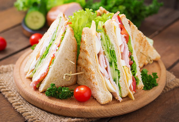 Club sandwich with cheese, cucumber, tomato, ham and eggs.