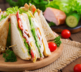 Club sandwich with cheese, cucumber, tomato, ham and eggs.