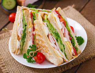 Club sandwich with cheese, cucumber, tomato, ham and eggs.
