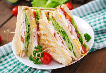 Club sandwich with cheese, cucumber, tomato, ham and eggs.