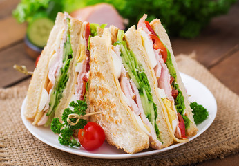 Club sandwich with cheese, cucumber, tomato, ham and eggs.