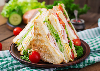 Club sandwich with cheese, cucumber, tomato, ham and eggs.