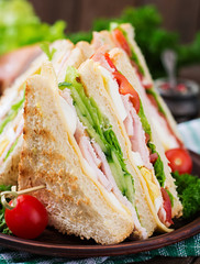 Club sandwich with cheese, cucumber, tomato, ham and eggs.