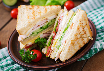 Club sandwich with cheese, cucumber, tomato, ham and eggs.