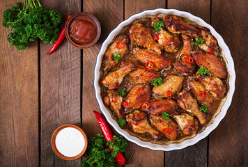 Sour-sweet baked chicken wings and sauce.Top view