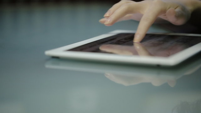 Fine young woman fingers slide on the screen tablet computer with white body