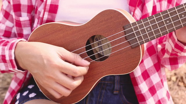 Asian woman child playing ukulele in the park
