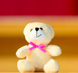 Soft toy closeup. Teddy bear toy. Cute toy with a pink bow. Beautiful and good bear.