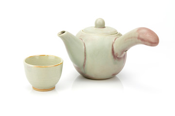 Ceramic teapot and tea cup isolated on white background