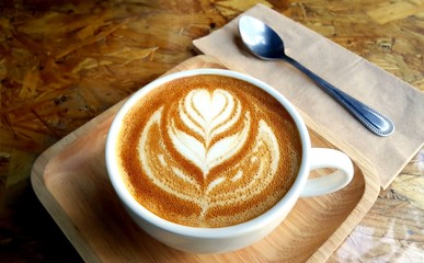 Cup of coffee with painted heart tree on foam