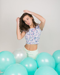 Young beautiful woman in white shorts and colorful top playing with balloons , slow motion