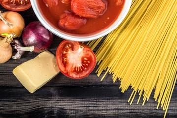 Ingredients of spaghetti bolognese arranged on wooden table.