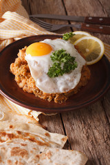 Arabic Breakfast: ful medames with a fried egg close-up. Vertical
