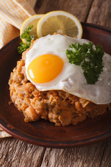 Arabic cuisine: ful medames with a fried egg close-up. vertical
