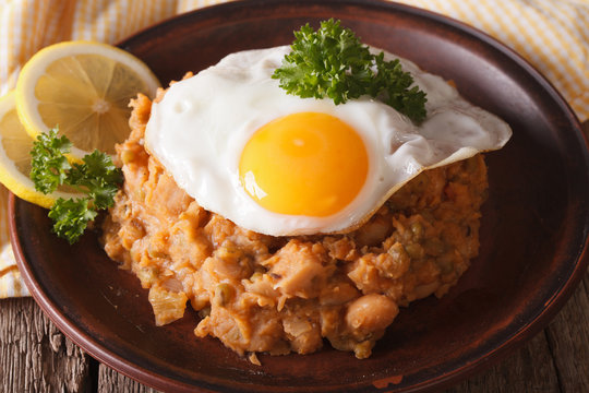 Arabic Breakfast: ful medames with a fried egg close-up. horizontal
