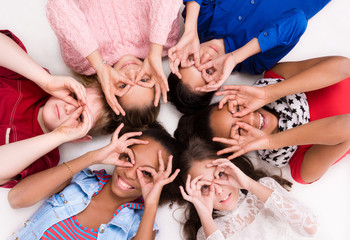Obraz premium children lying on the floor head to head with glasses out of fingers