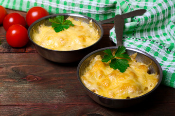 French cuisine. Сhicken with mushrooms baked with cheese in a cocotte