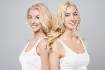 Two beautiful sisters have one braid .
