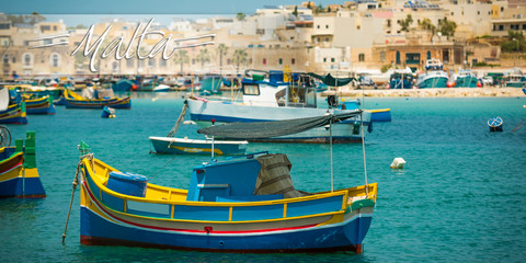 Fototapeta na wymiar postcard with fishing boats near village of Marsaxlokk