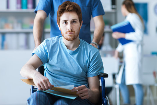 Healthcare Worker Pushing A Man In Wheelchair