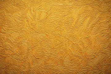 Gold background texture. Wallpaper on the wall.