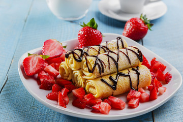 rolled pancakes with strawberries and chocolate breakfast
