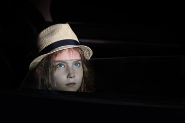 Pensive beautiful girl in a hat in the car