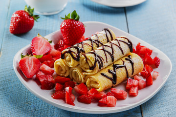 rolled pancakes with strawberries and chocolate breakfast