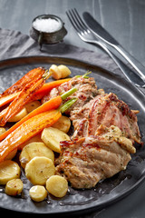 chicken meat and roasted vegetables on gray plate
