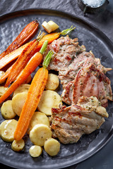 chicken meat and roasted vegetables on gray plate
